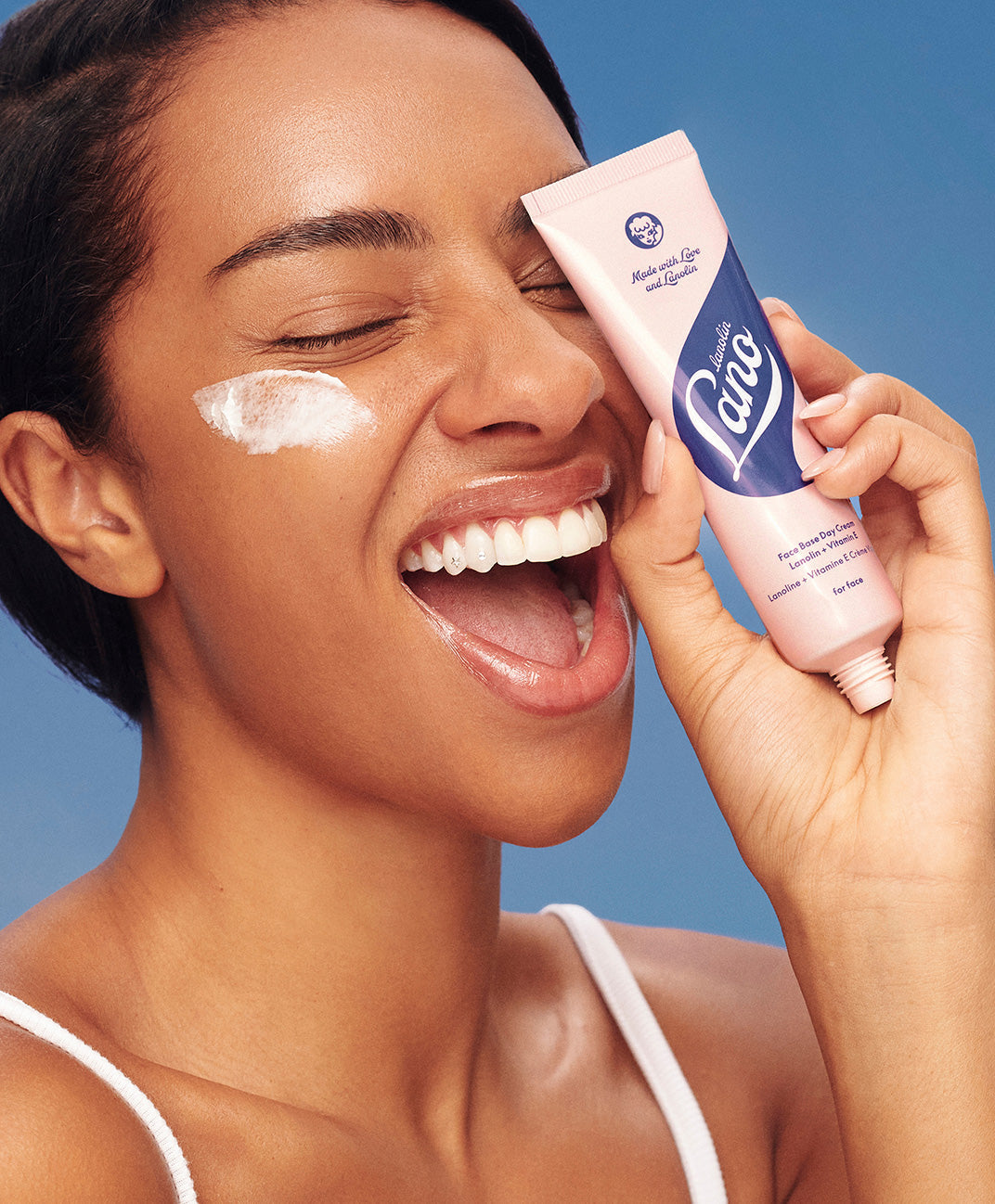 Model holding lanolips face base vitamin e cream in her hand.