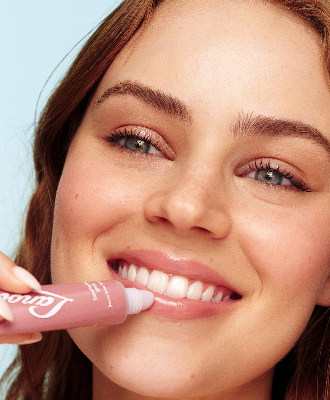 Model holding lanolips 101 ointment tubes in various flavours.