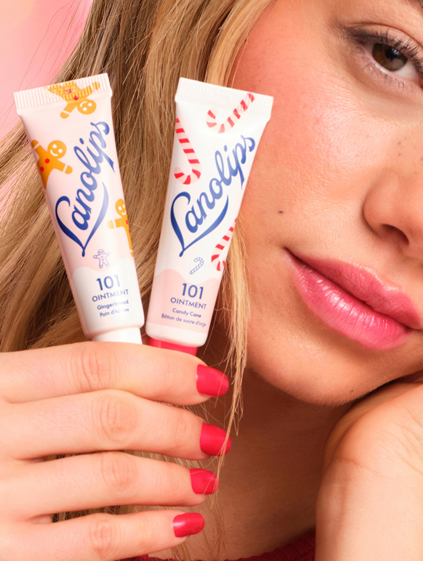 Model holding Lanolips 101 Ointment Multi-Balm Gingerbread & Candy Cane from the limited-edition Holiday Gingerbread House collection.