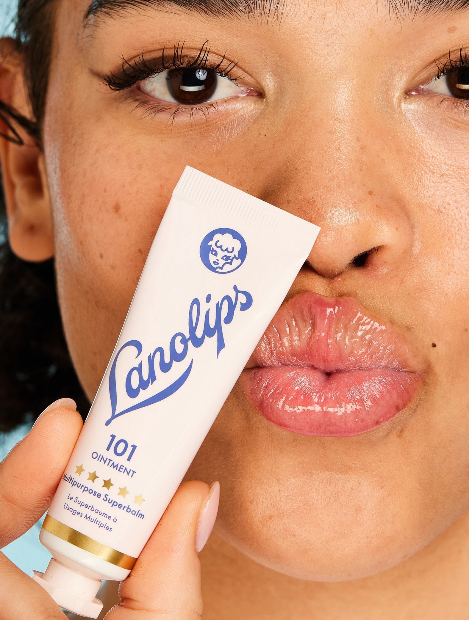 Close up a model puckering their lips while holding a tube of Lanolips The Original 101 Ointment Multipurpose Superbalm close to her face. This 100% natural, multi-award-winning balm is a powerful multi-tasker with 101 uses—from ultra-hydrating lips to soothing dry skin. Voted ‘The World’s Best Lip Balm,’ it’s a hard-working formula designed to deeply nourish and lock in moisture. Made with 100% ultra-pure grade lanolin, it mimics the skin’s natural oils, leaving lips soft, smooth and glossy.