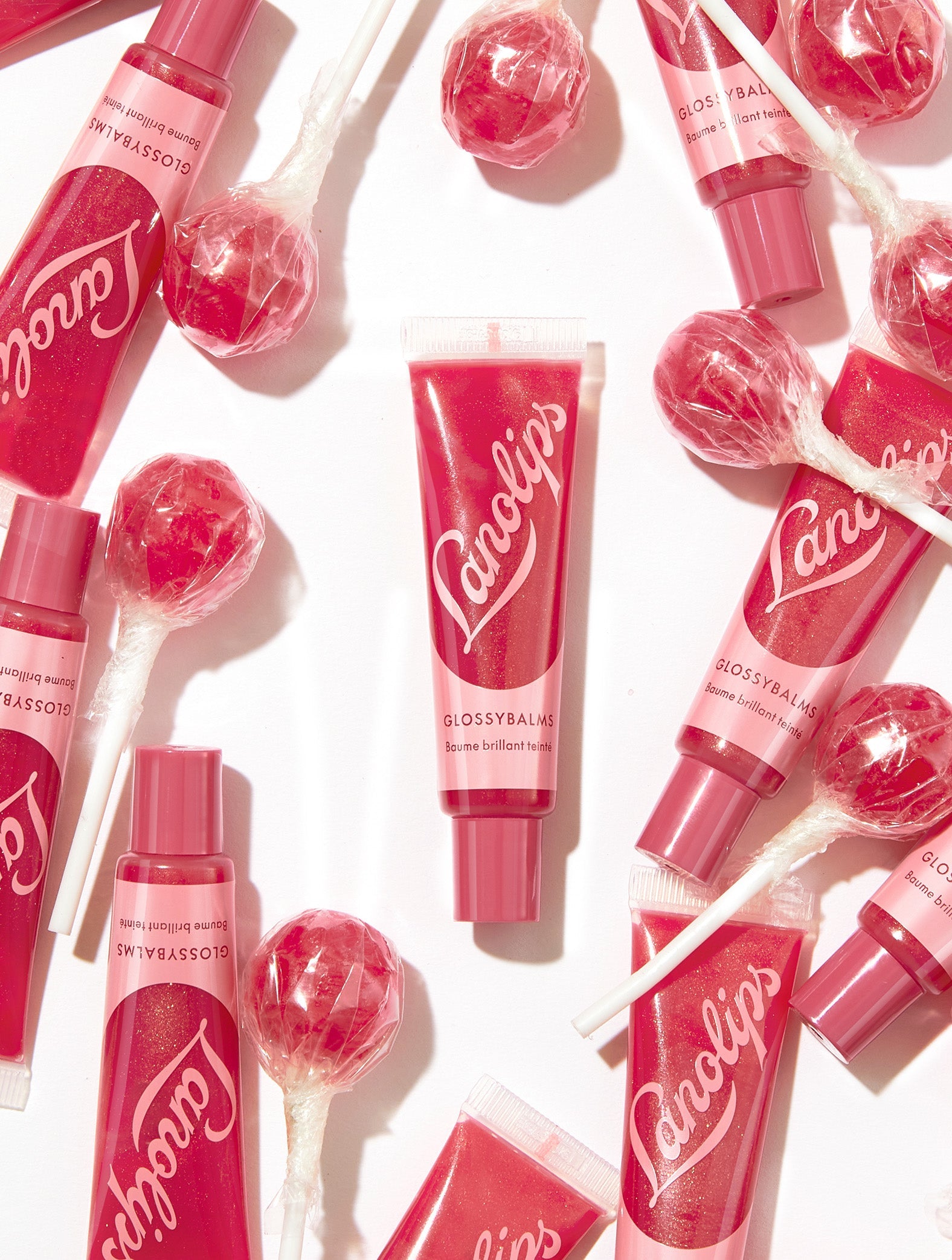 Group product shot of the Lanolips Glossy Balms Candy tubes surrounded with lollypops.